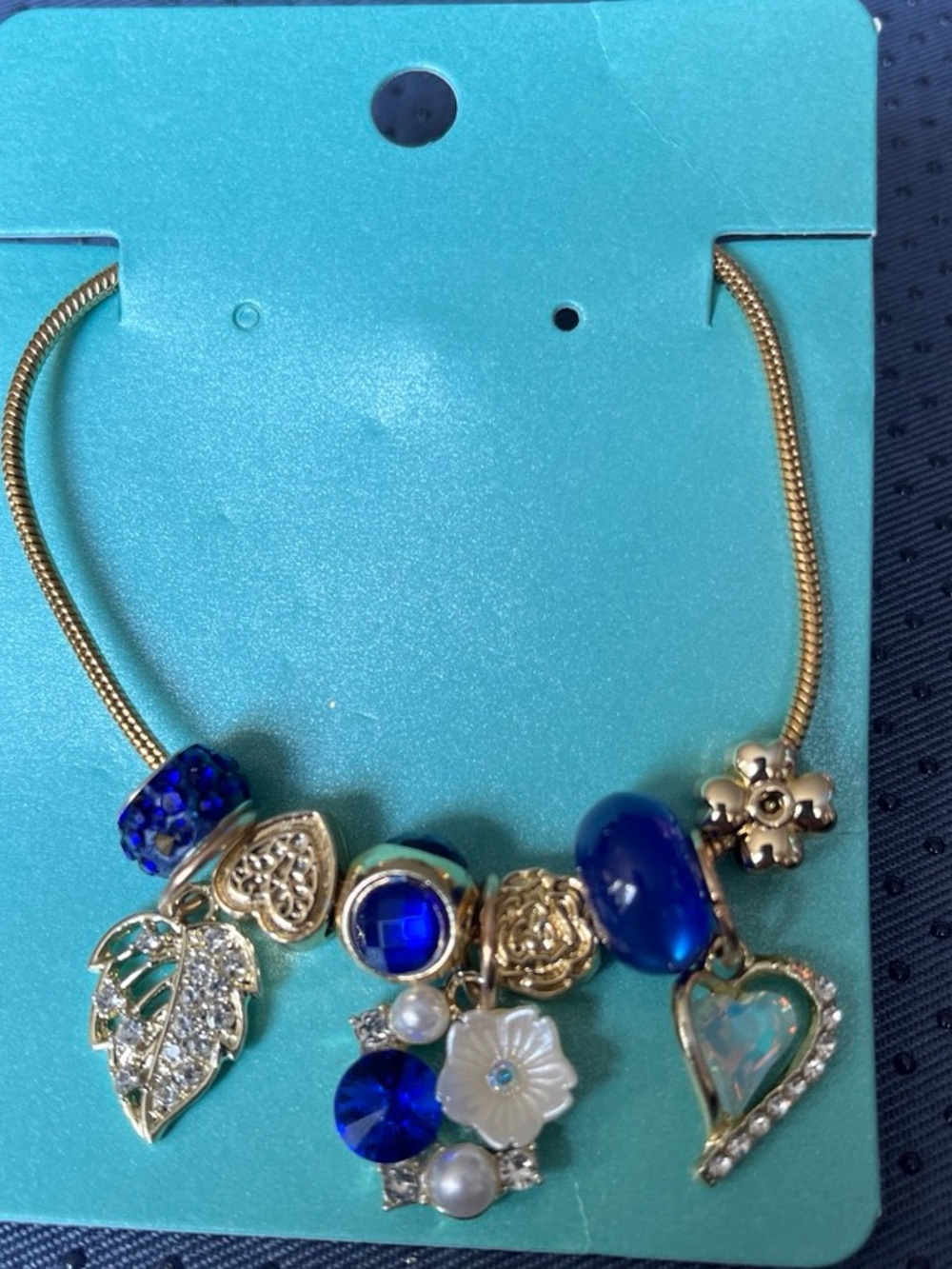 Gold-Tone Blue Charm Necklace with Heart and Floral Accents